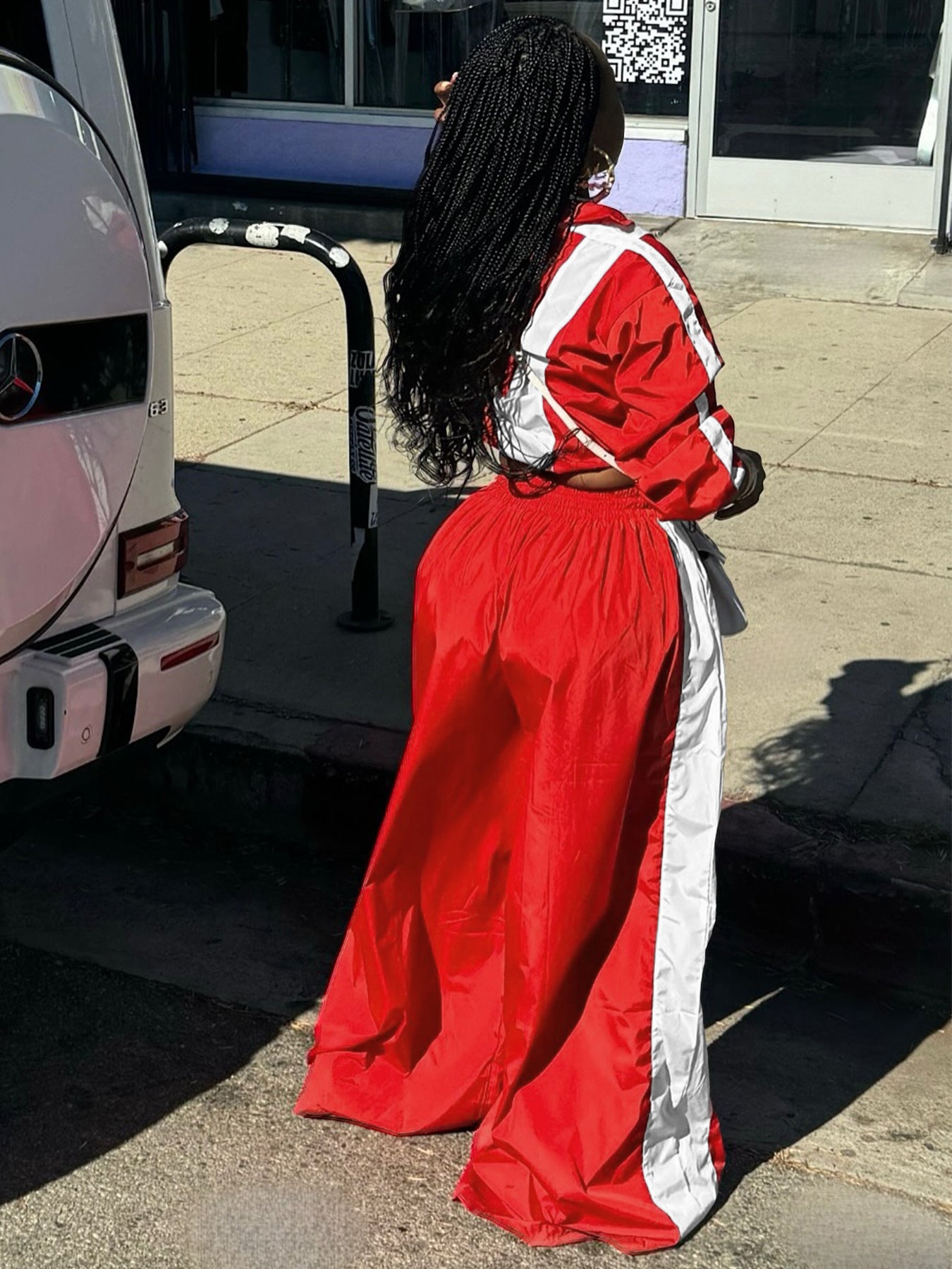 Person wearing a red and white outfit getting into a vehicle.